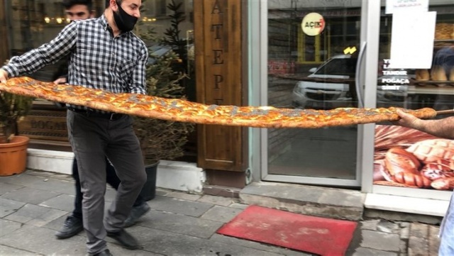 Kilolarca hamurdan yapılan 2 metrelik 'Evde Kal Türkiye' yazılı pide açık artırmayla satıldı.